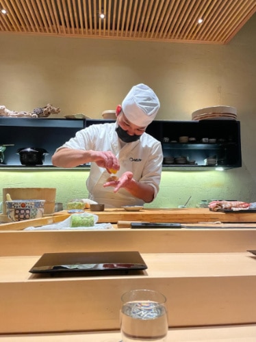 The chef preparing food on the counter in Omakase