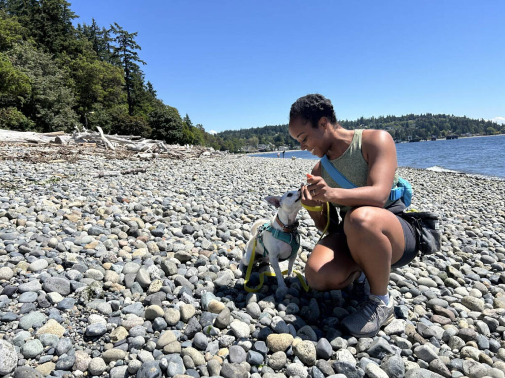 The author Chelsea Booker feeding Toby, her dog at a beach