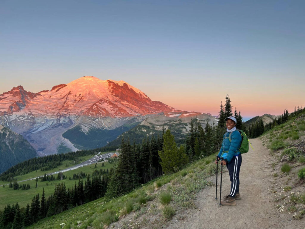 Travel Lemming editor, Chelsea Booker smiling for a photo with the Mount Rainier National Park on the background
