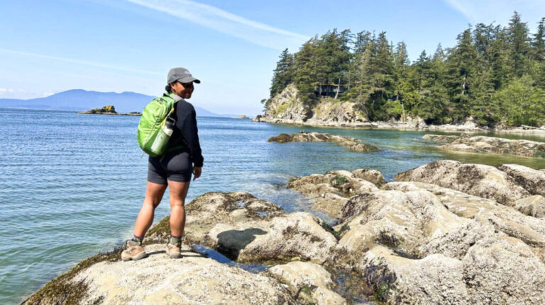 The author, Chelsea Booker, standing on a rock with a scenic view in the background