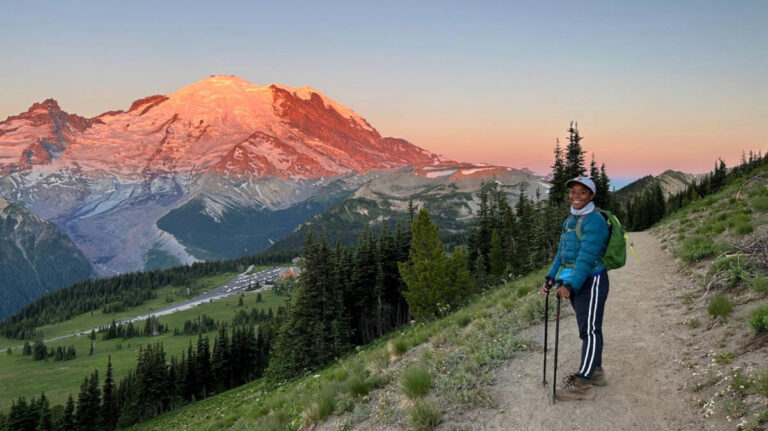 Travel Lemming editor, Chelsea Booker smiling for a photo with the Mount Rainier National Park on the background