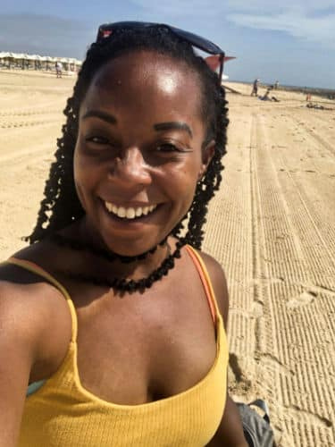 The author Chelsea Booker enjoying the sand of Praia da Ilha de Tavira