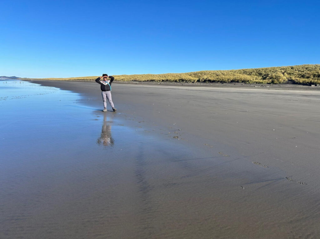 The author Chelsea Booker, standing at the vast Oregon Coast