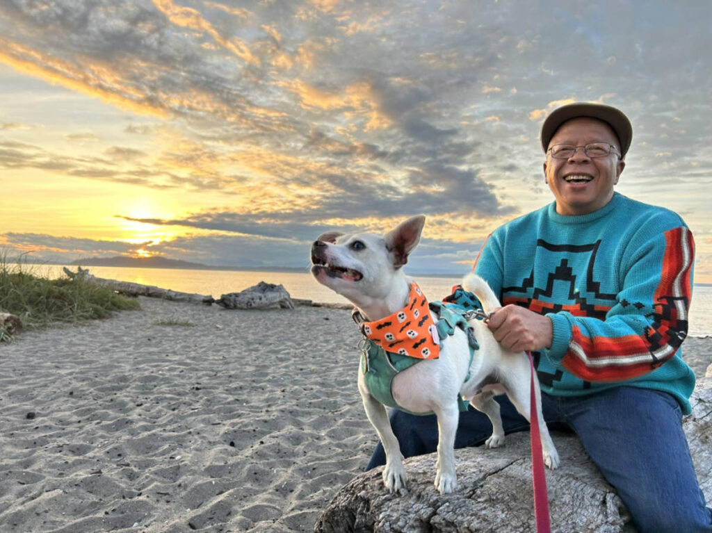 The author's dad and dog enjoying the sunset on Alki Beach