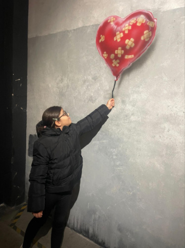 The author's daughter, interacting with the art at the Banksy Museum