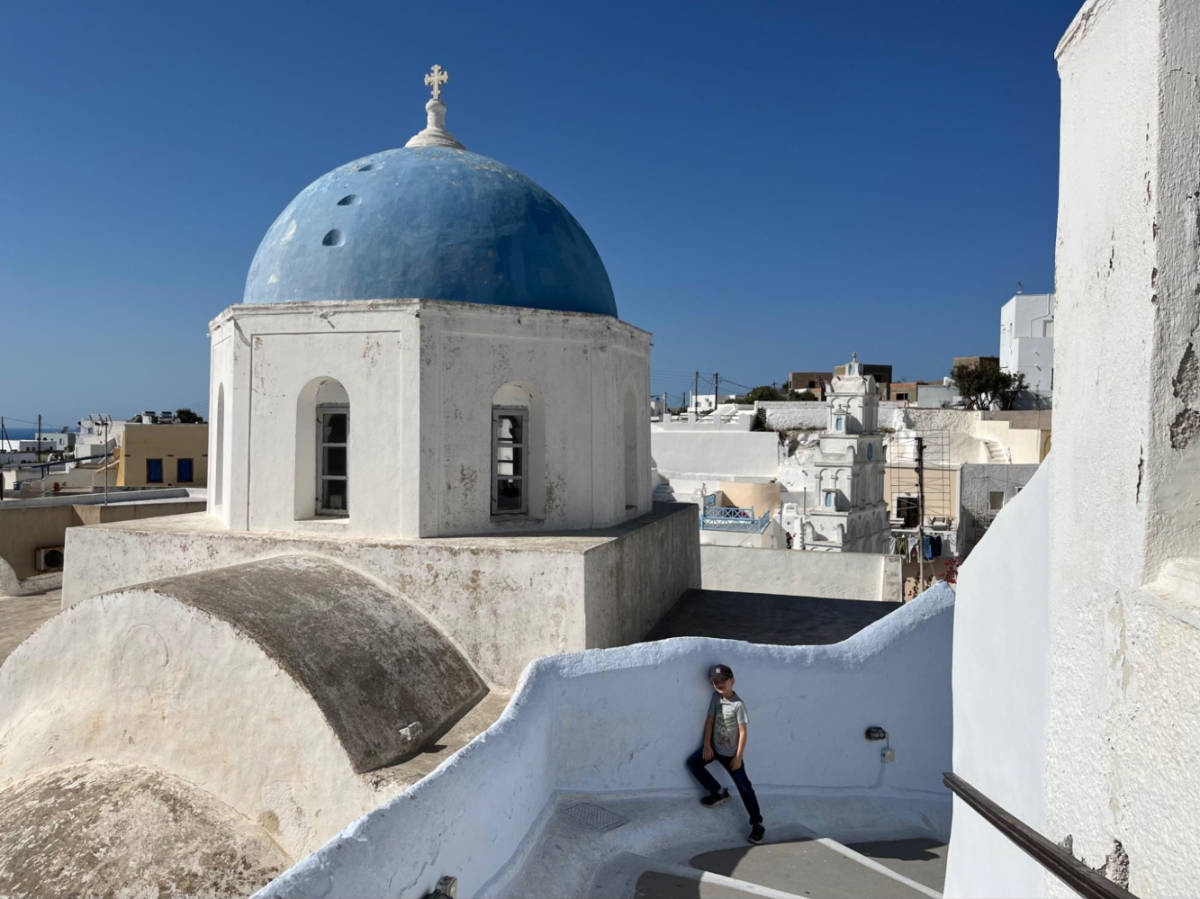 A child in front of a blue dome in Megalochori