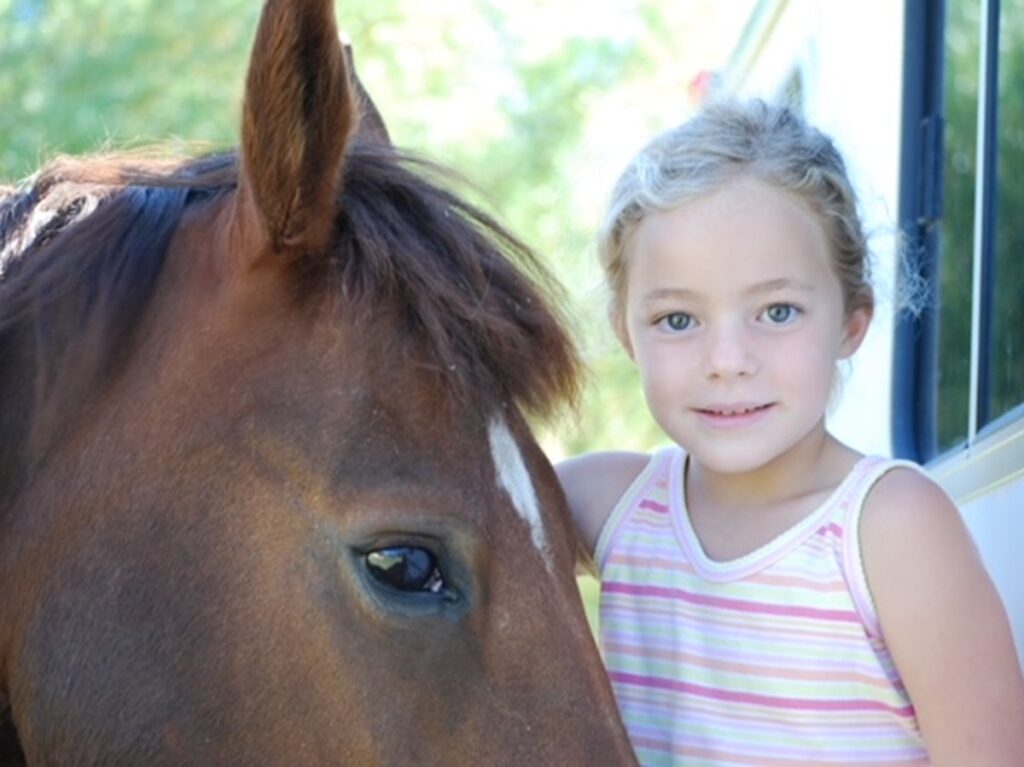 A child smiling with a horse