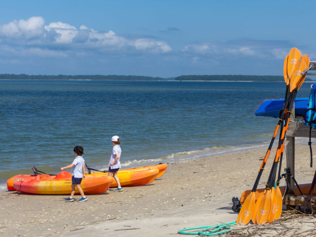 Two boys explore the orange kayaks