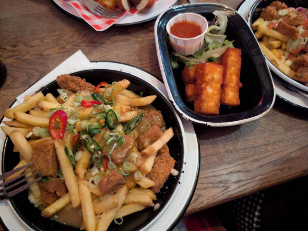 Closeup look of the salt and chilli popcorn seitan poutine and halloumi sticks at Bloc+