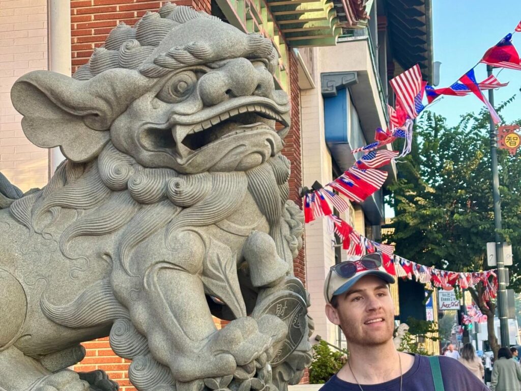 Michael posing for a photo with the Chinatown lion statues
