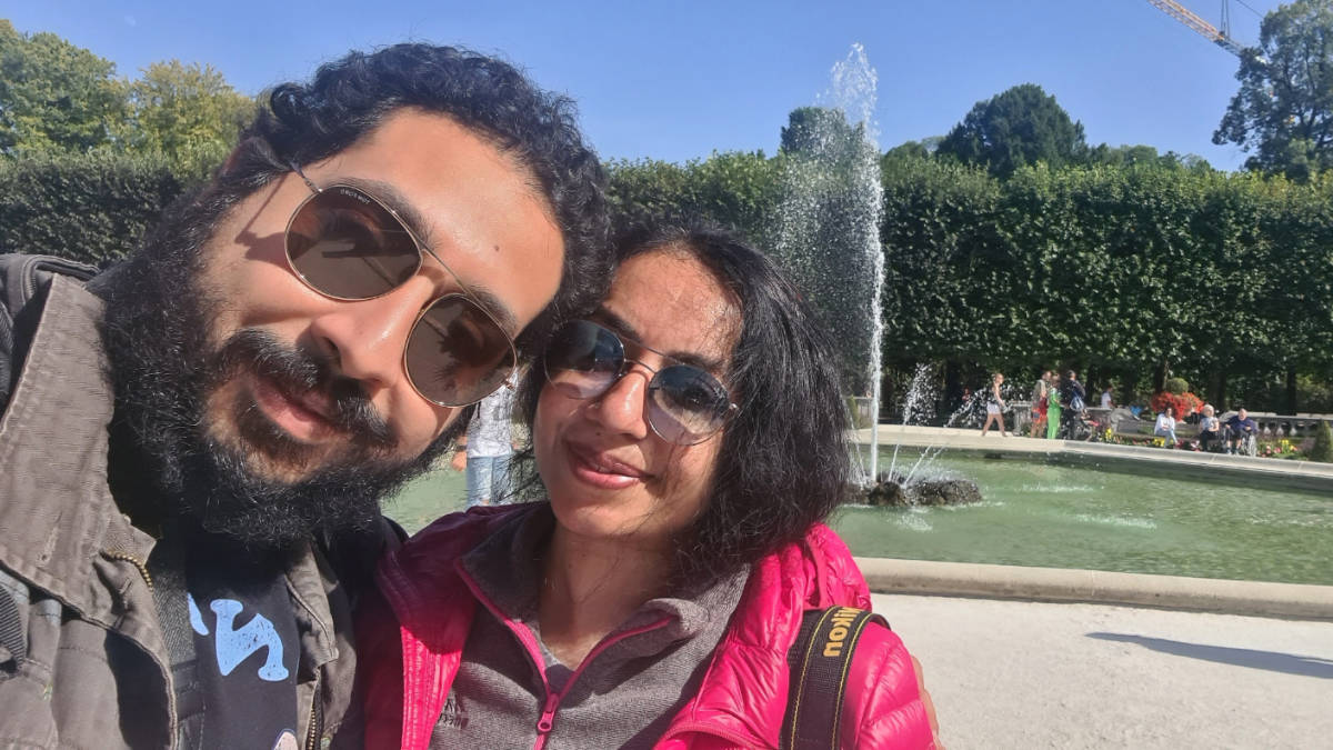 The author, Christina Daniels smiling for a photo with the water fountain in Mirabell Palace on her background