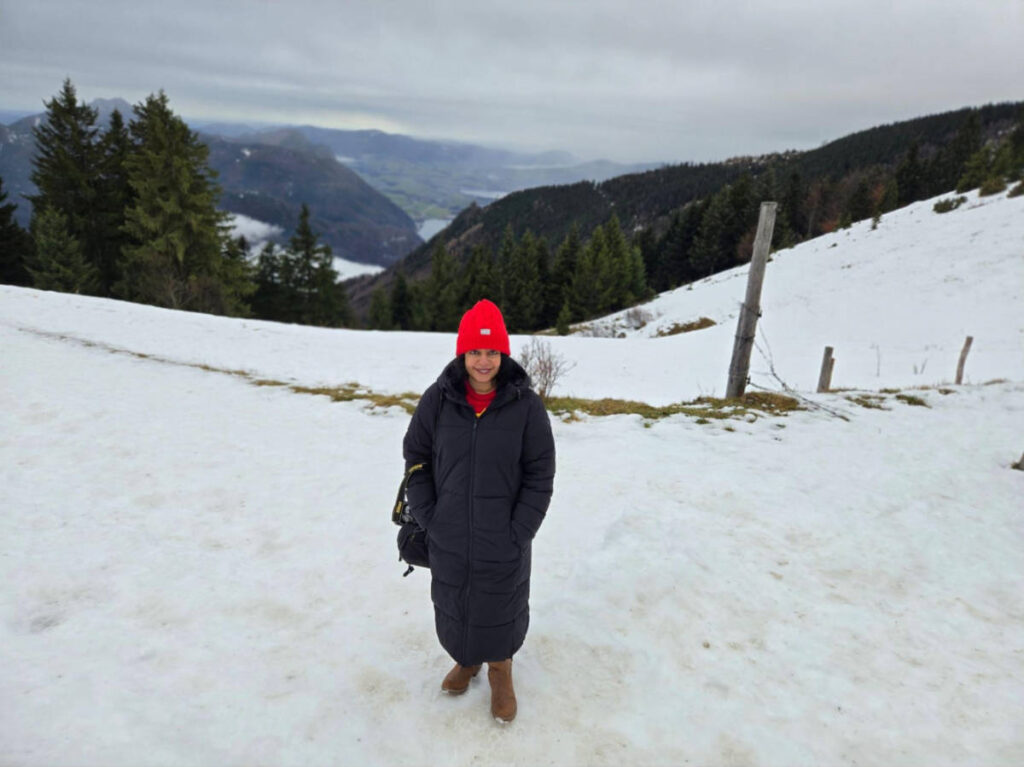 The author Christina Daniels, smiling for a photo in the snow covered Wolfgangsee in winter