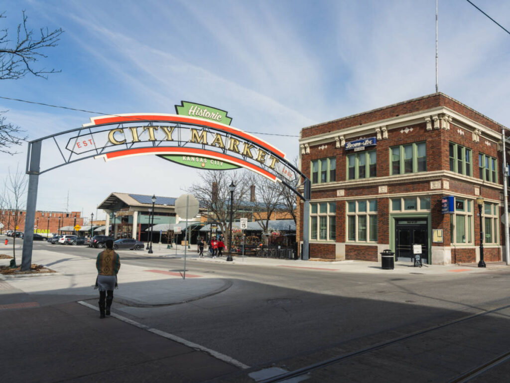 View of the City Market arch sign and the brick walled building nearby