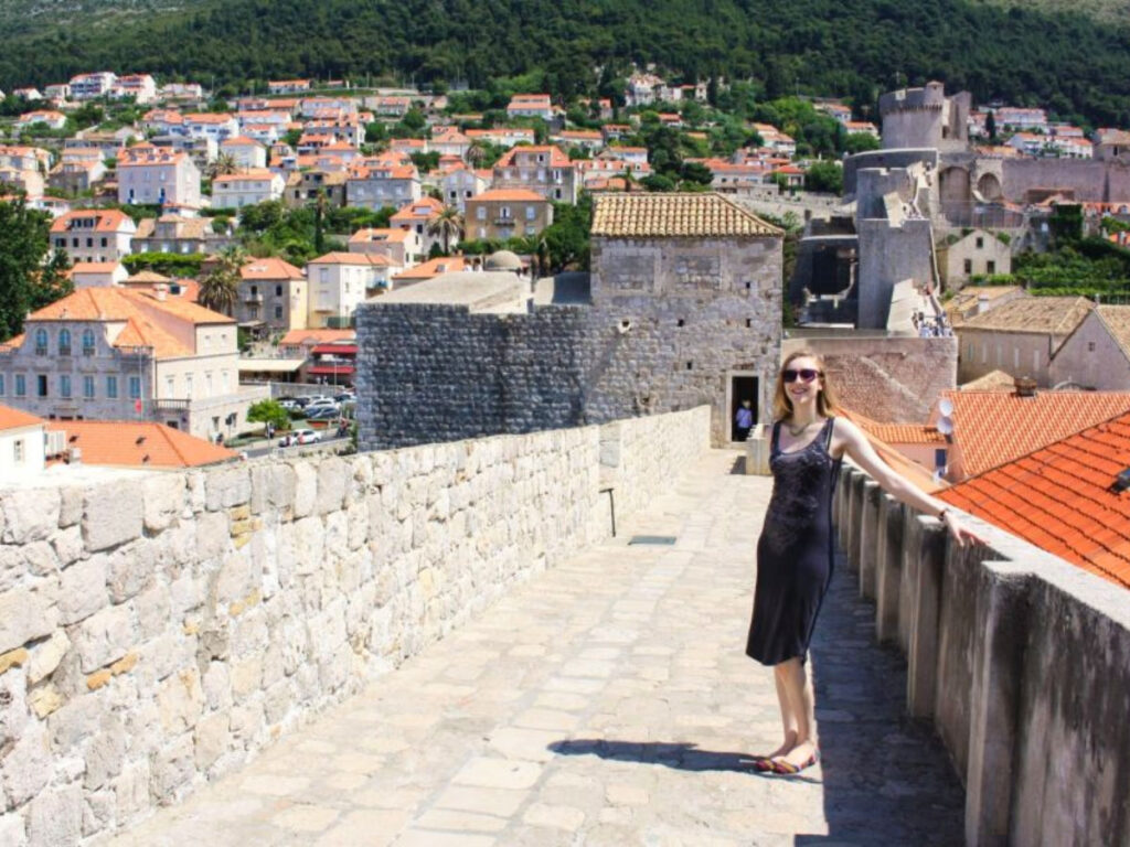 A woman standing on Dubrovnik's stone walls