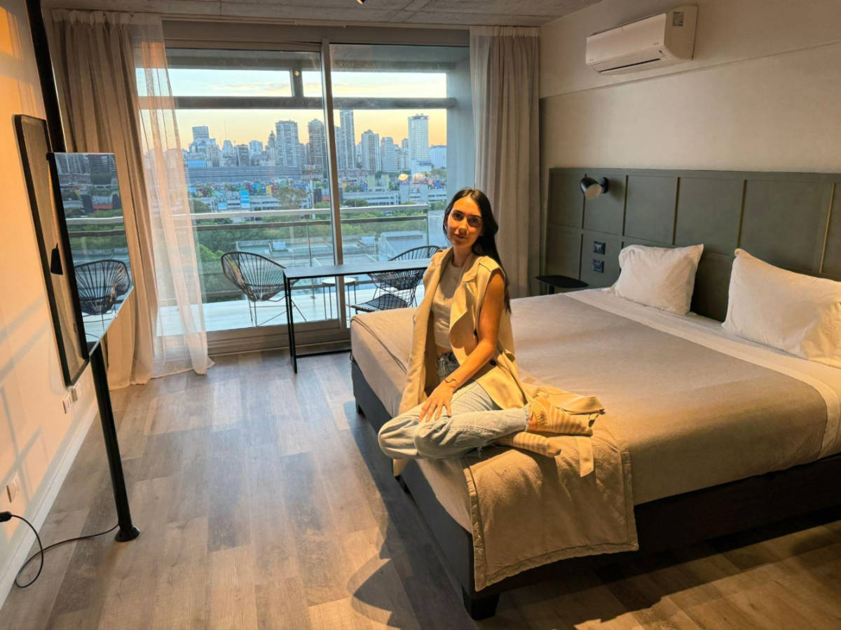 Travel Lemming writer Clara Kesseler, sitting on the bed inside the room at Almarena Puerto Retiro Affiliated by Melia