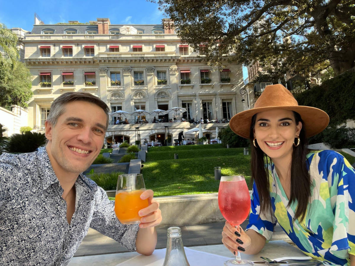 Travel Lemming founder, Nate Hake and Clara Kesseler, enjoying their drink at an open area surrounded by greenery outside Palacio Duahu