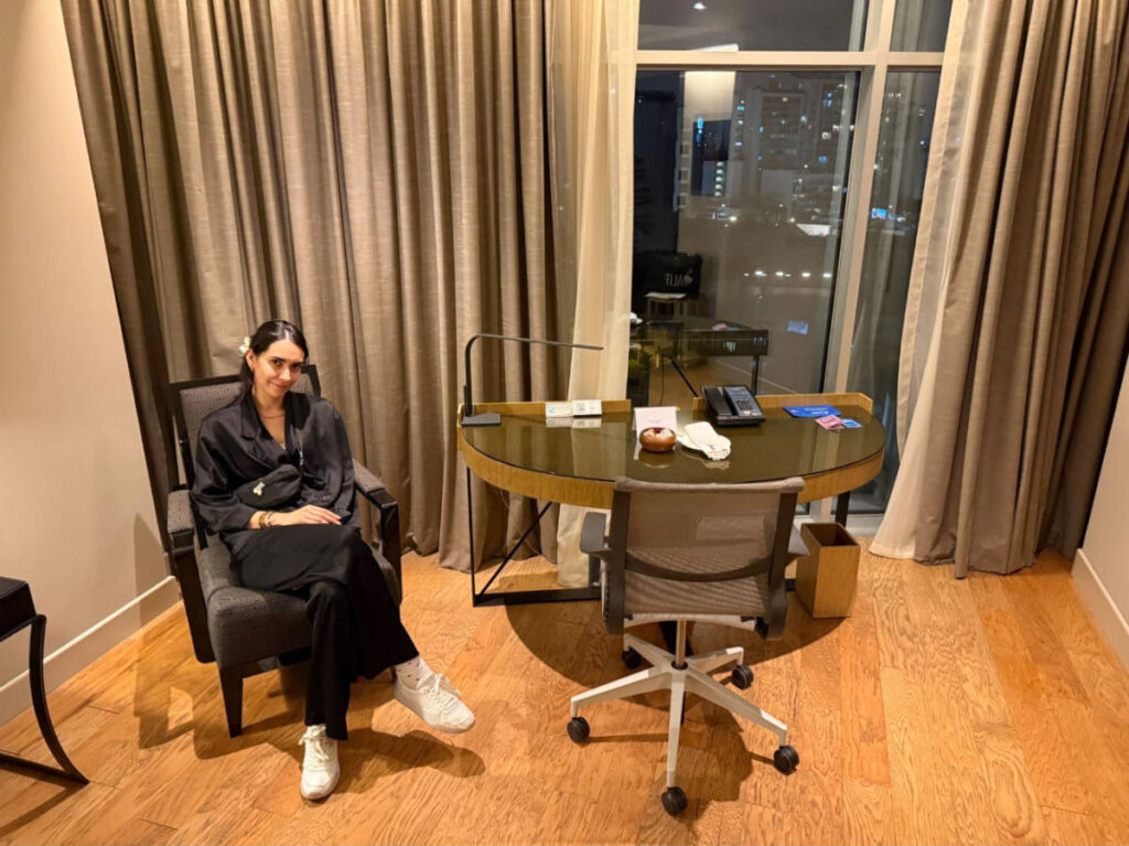 Clara Kesseler in front of their desk on their room in Hilton Lima Miraflores
