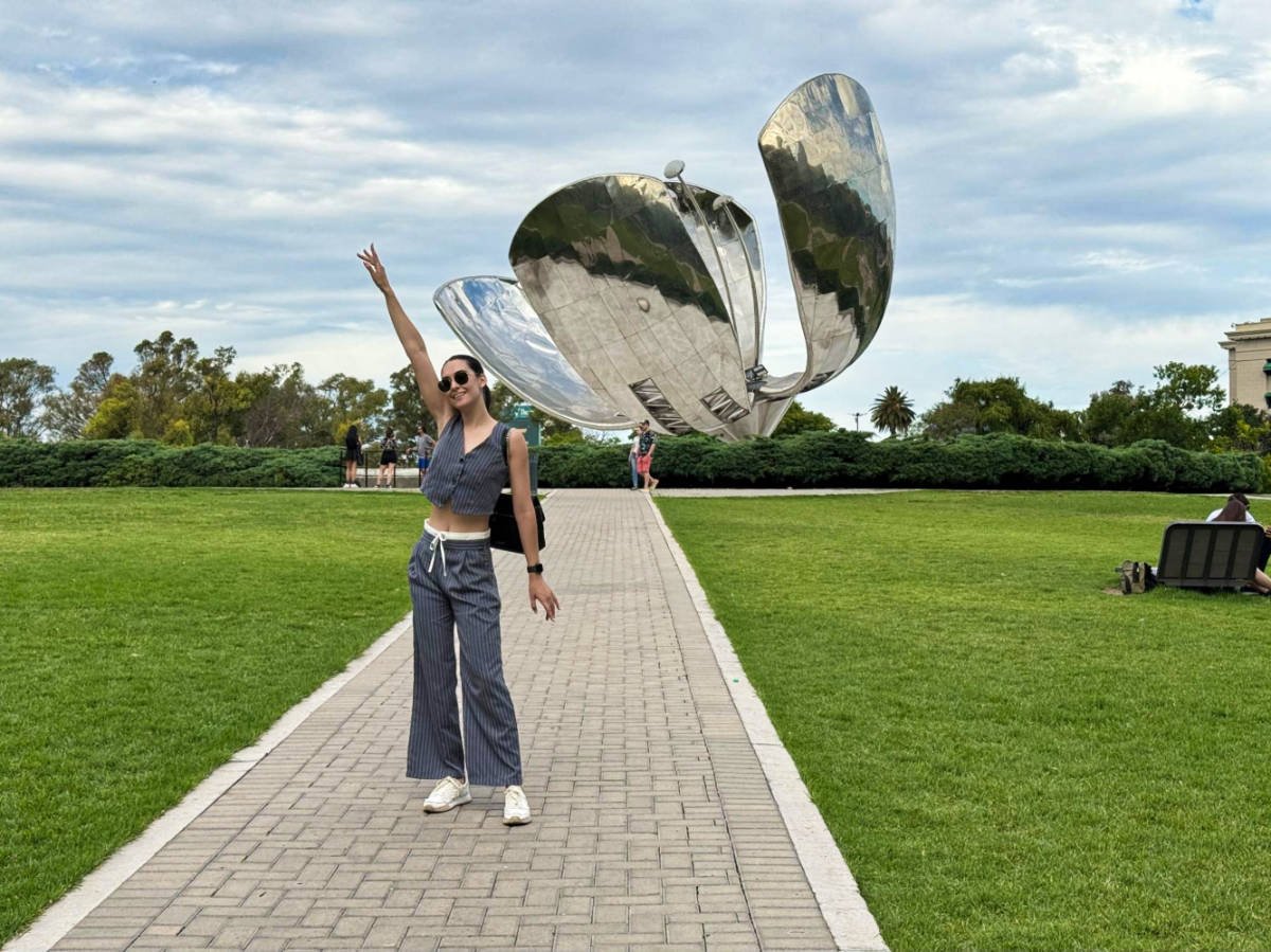 Clara Kesseler posing for a photo with the Floralis Genérica in the background
