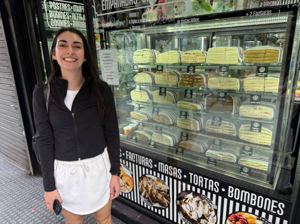 Clara Kesseler posing for a photo in front of the sandwich store display