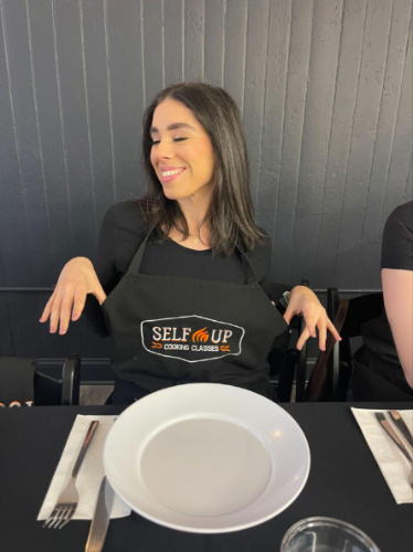 The author Claudicet Pena, with an apron on in Selfup Boston