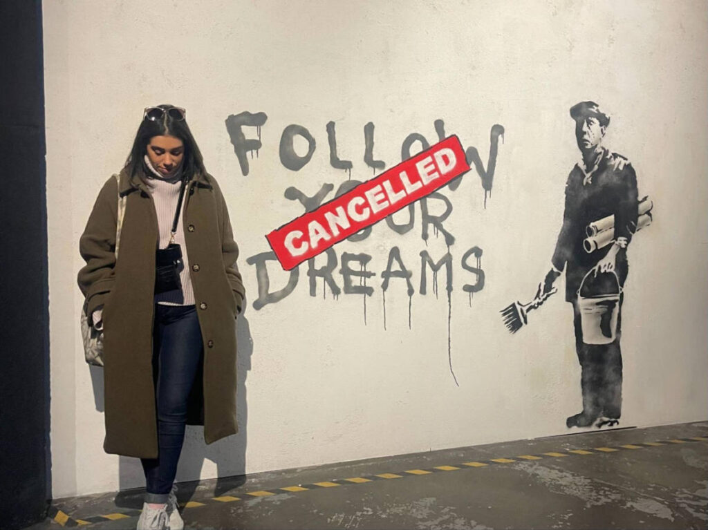 The author Claudicet Pena, posing for a photo at the Banksy Museum