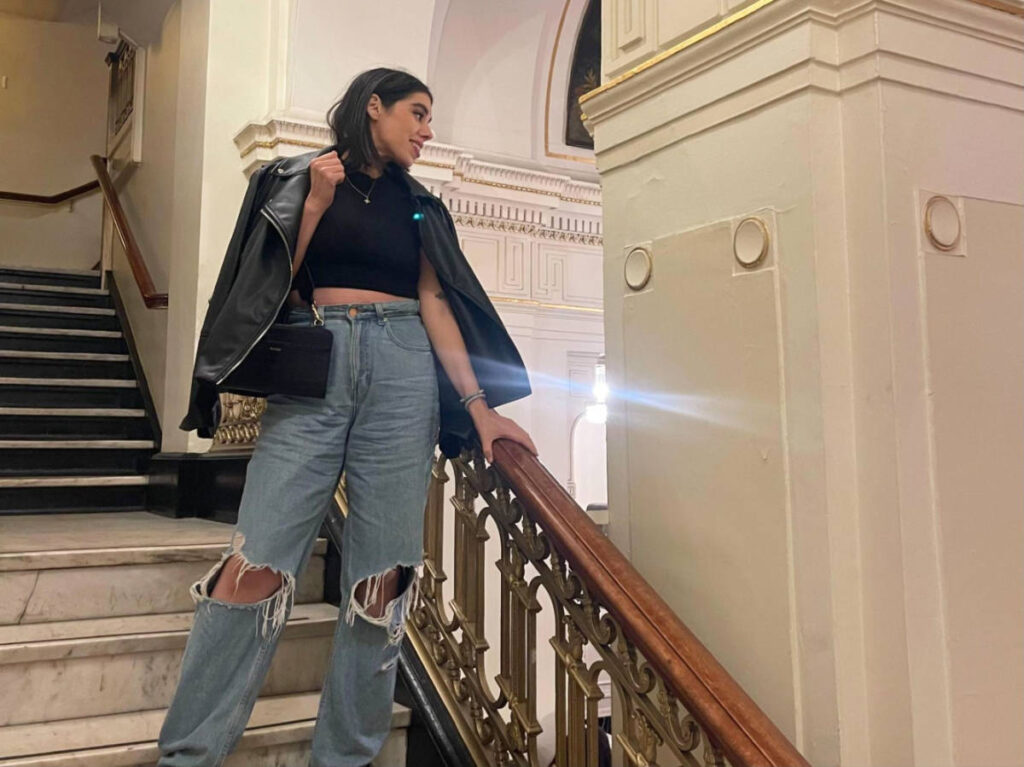 The author Claudicet Pena, posing for a photo on the staircase in Boch Center-Wang Theatre
