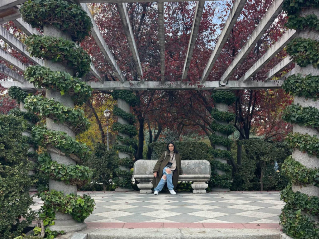 The author Claudicet Pena, sitting on a bench in the Jardines de Cecilio Rodríguez, Parque de Retiro