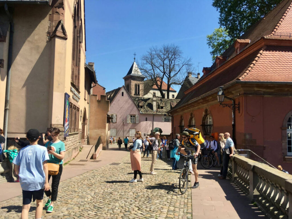 People walking on the cobblestoned Strasbourg street on a sunny day