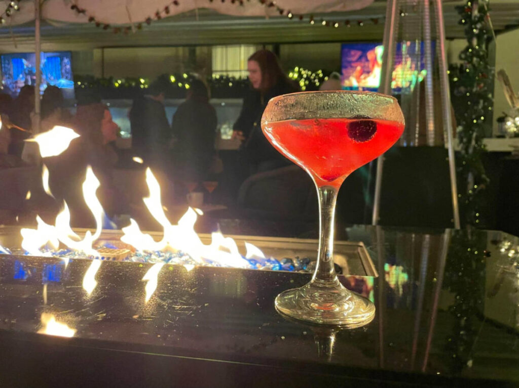 A Holiday cocktail near the fireplace at Dirty Habit Ski Chalet pop up