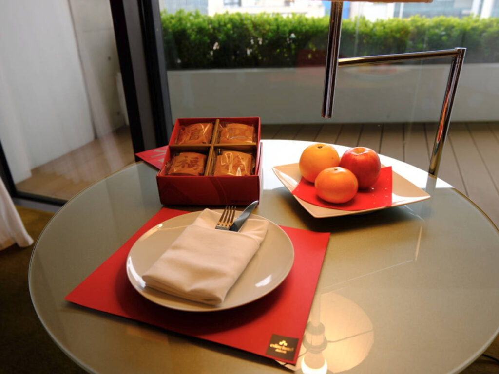 A round table with cookies and oranges in the hotel room