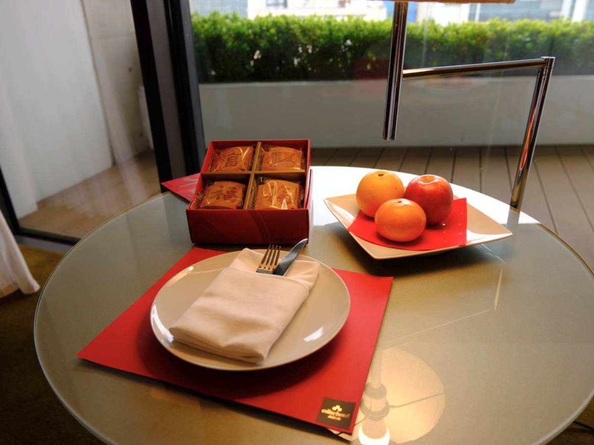 A round table with cookies and oranges in the hotel room