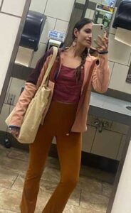 The author smiling for a mirror selfie wearing her Cotopaxi Abrazo Hooded Full-Zip Jacket