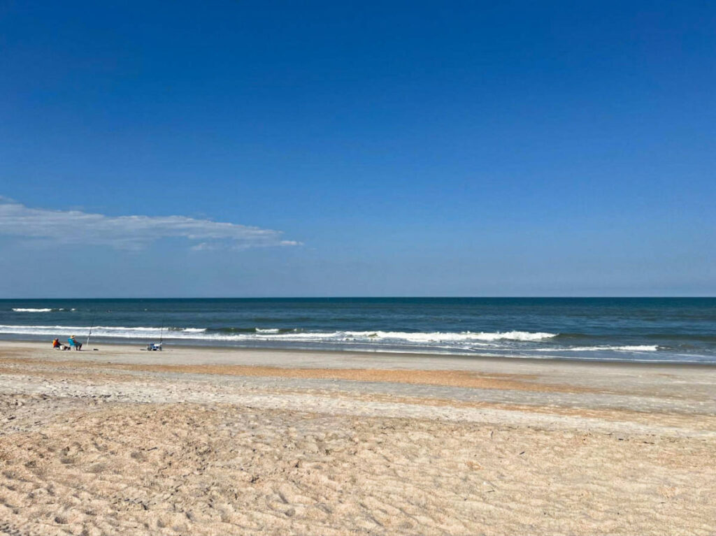 A couple sitting along the shoreline in Jacksonville Beach