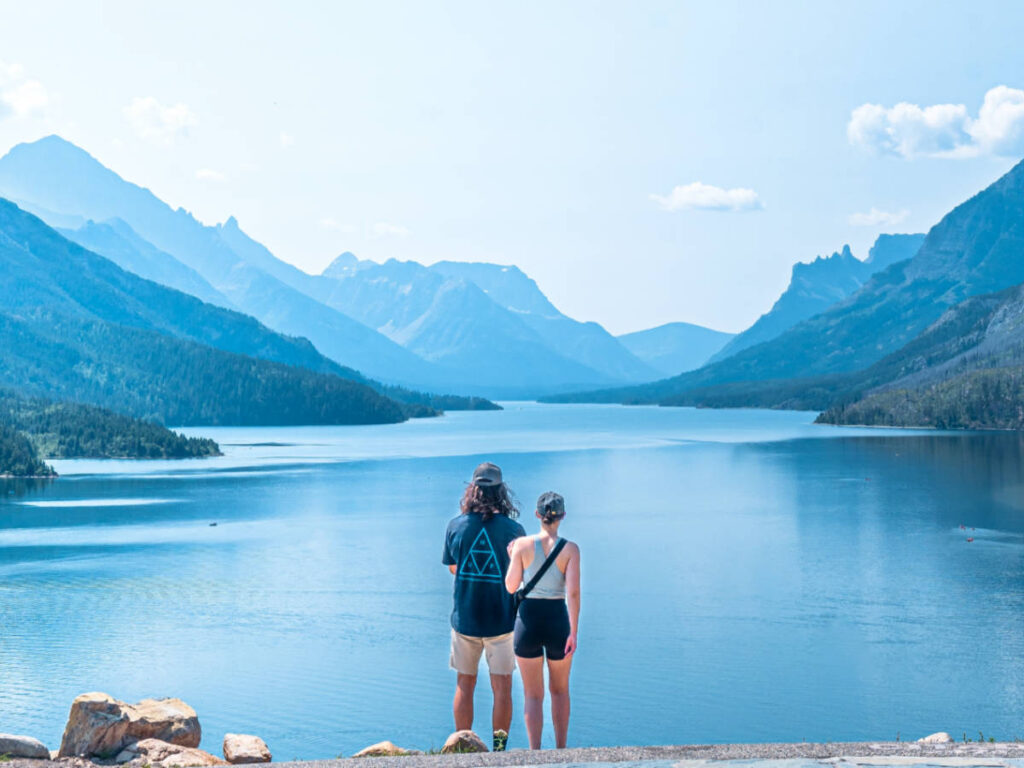 A couple admiring the scenic view of the mountain valleys around the Waterton Lakes
