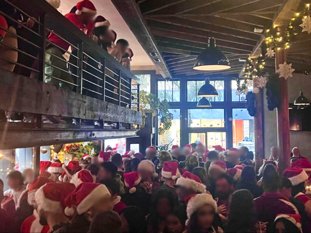 The crowd wearing Santa hats inside a bar in Polk Gulch