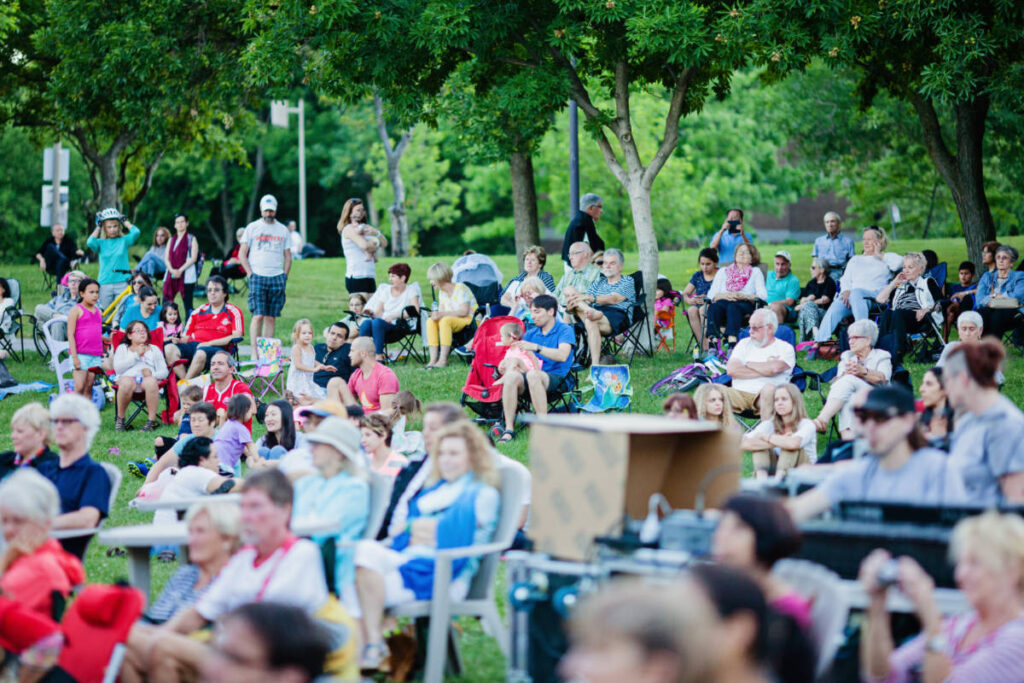 People sitting on their portable chairs watching a concert at Spreckels Park