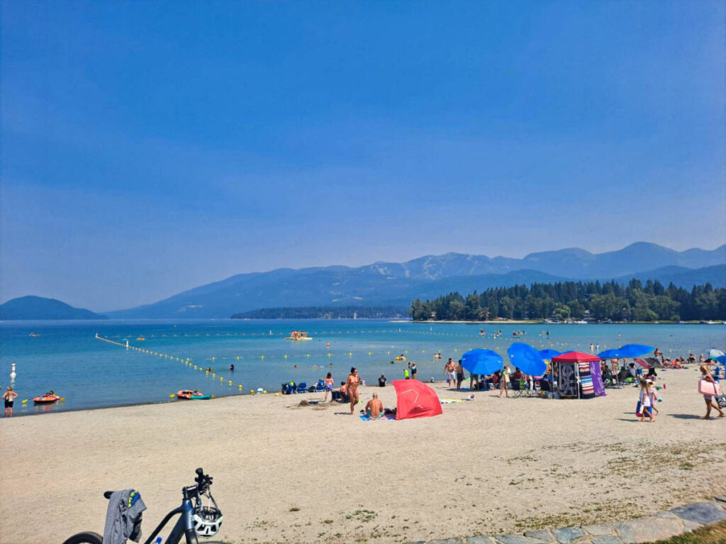 View of the crowd enjoying the white sand at Whitefish Lake
