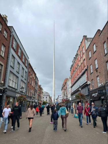 View of the crowd walking around with the Spire of Dublin in the distance