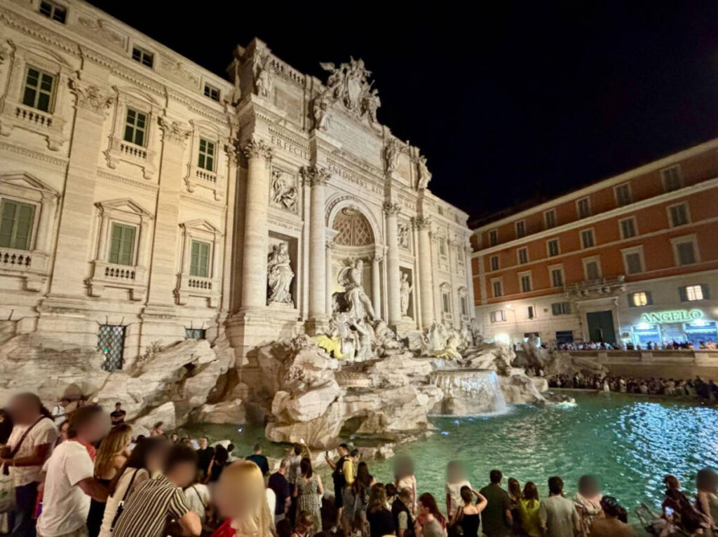 The crowd around the Trevi Fountain at night