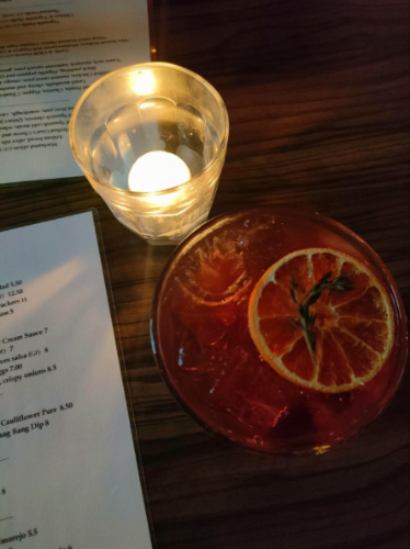 A glass of Cubatas signature cocktail next to the candle