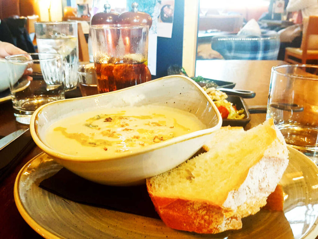 A bowl of the traditional Scottish soup with sliced bread on the side