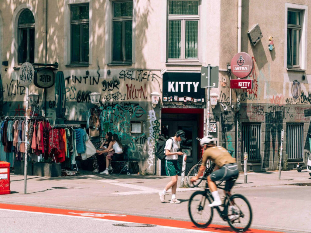 A man cycling in front of the vintage shop in the street