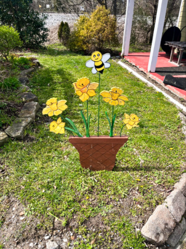A decor of potted yellow flowers with a bee on Daffodil Day