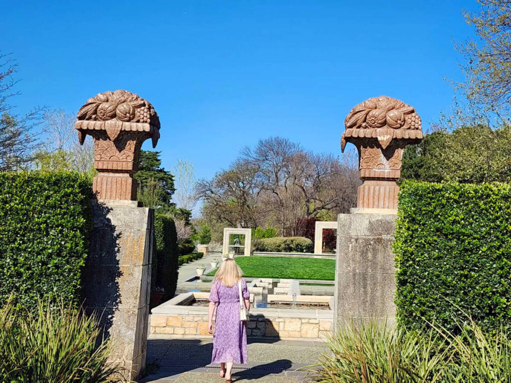 Author Sarah Heath entering a path in the Dallas Arboretum and Botanical Gardens