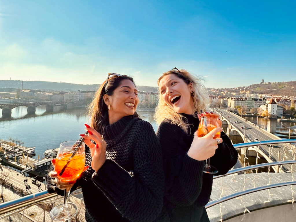 Author Meera and her friend enjoying a drink at Dancing House Glass Bar