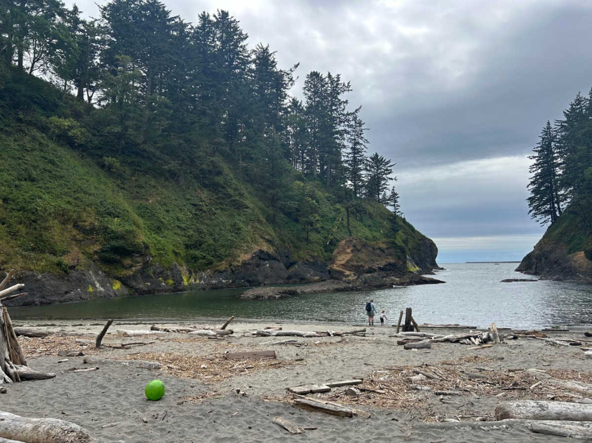 People exploring Deadman’s Cove surrounded by greenery at Cape Disappointment State Park