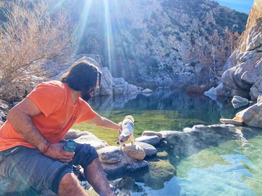 The author's dog and a man at the Deep Creek Hot Springs