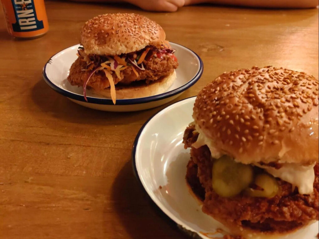Plates of Smokey’s Nashville and chicken burgers at Dennistoun Bar-B-Que