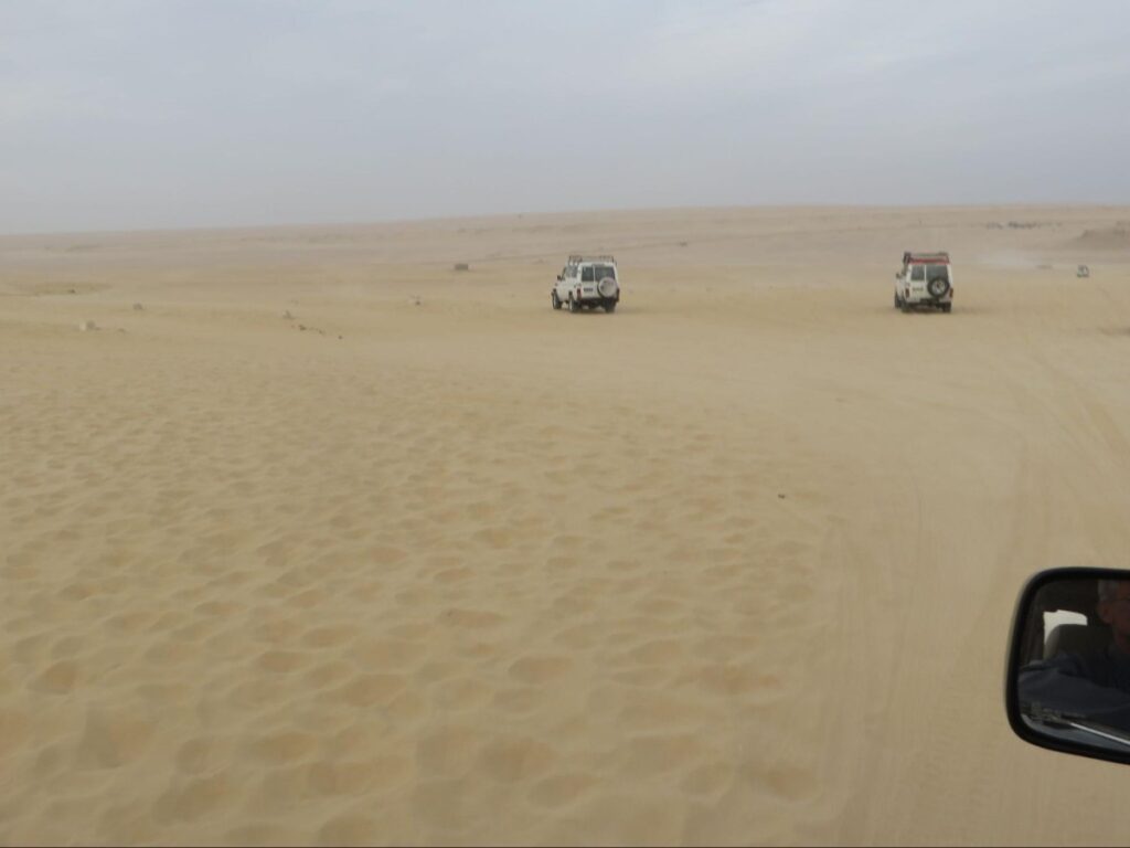 4x4 vehicles driving across the Egyptian desert during a safari tour