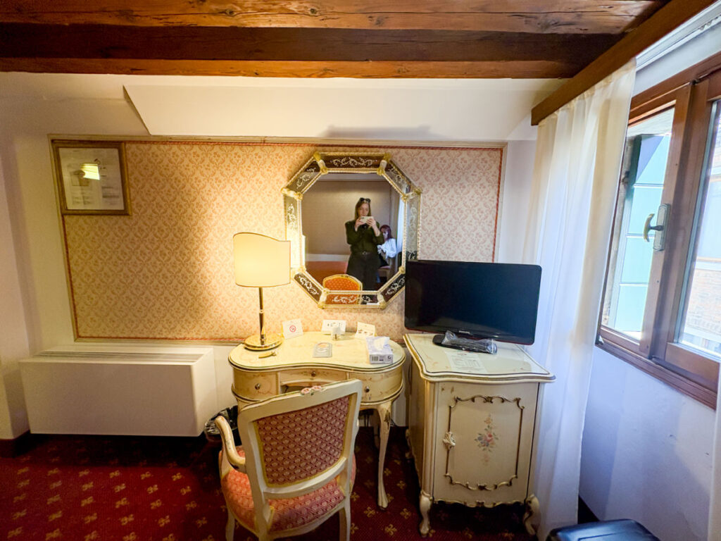Author Taylor taking a mirror picture at the desk area at Hotel Rialto
